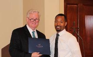 A professor presenting an award to a student.